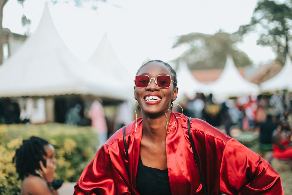 Žena u sunčanim naočalama i crvenom izdanju na otvorenom festivalu